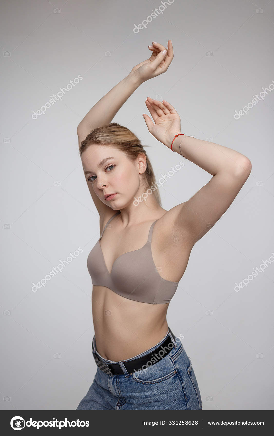 Young caucasian woman posing in blue bra and jeans Stock Photo by