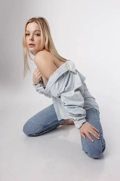 Sexy caucasiano menina posando em azul jeans e camisa no branco estúdio fundo — Fotografia de Stock