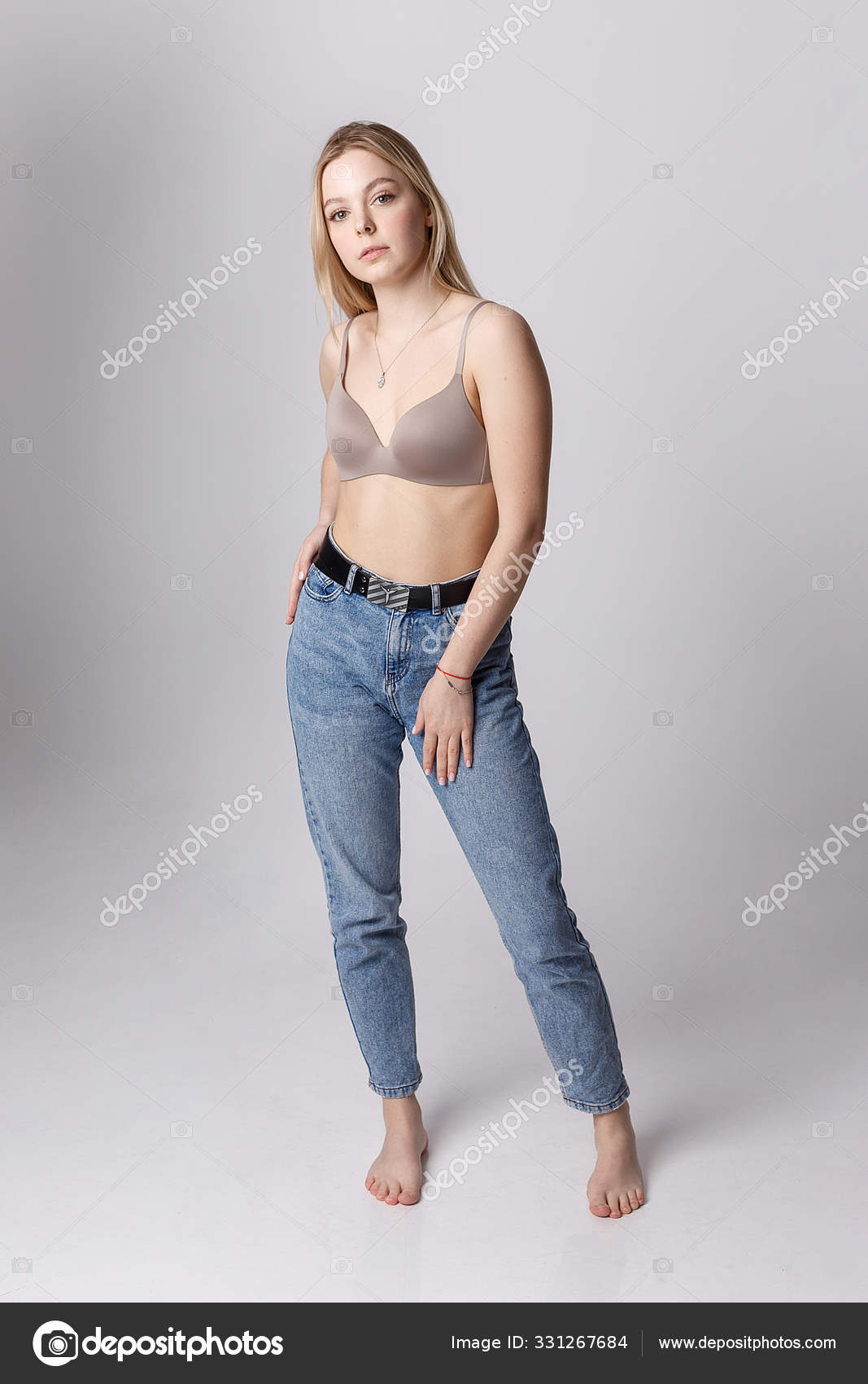 Young caucasian woman posing in blue bra and jeans. Stock Photo