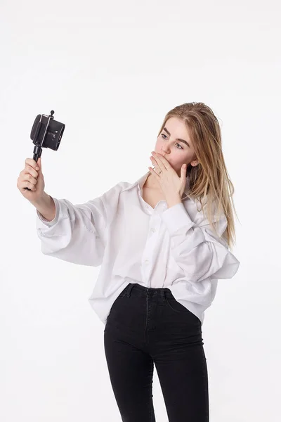 Gelukkig jong meisje het maken van zelfportret met smartphone bevestigd aan kleine statief — Stockfoto