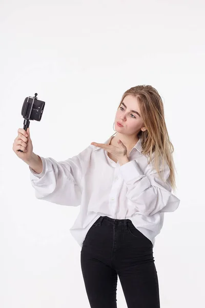 Menina feliz fazendo auto retrato com smartphone ligado a pequeno tripé — Fotografia de Stock