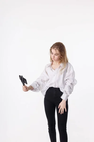 Jong mooi meisje maken zelfportret met smartphone bevestigd aan kleine statief — Stockfoto