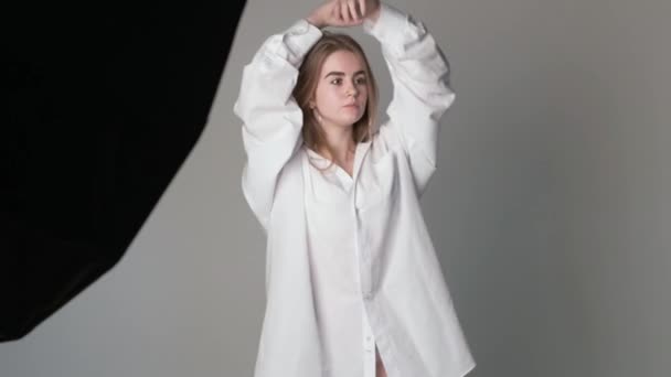 Hinter den Kulissen beim Fotoshooting: Schönes junges Model posiert für Fotograf — Stockvideo