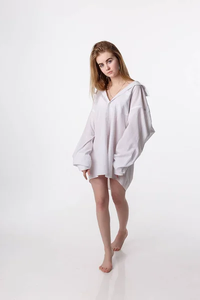 Young pretty female wearing shirt posing in studio with bare feet, model tests — 스톡 사진