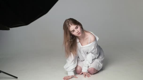 Achter de schermen op fotoshoot: mooi jong model poseren voor fotograaf — Stockvideo
