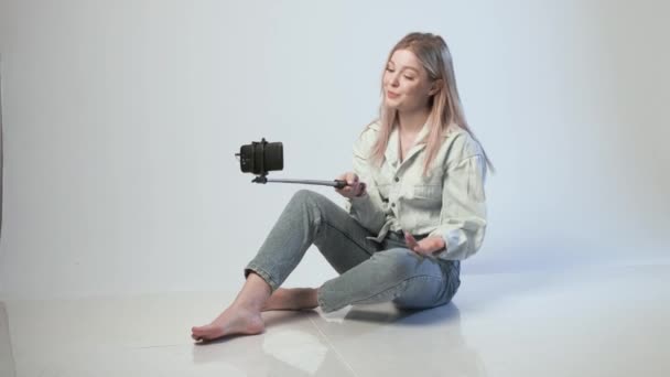 Heureux enregistrements vidéo femelle pour vlog avec smartphone attaché à selfie stick — Video