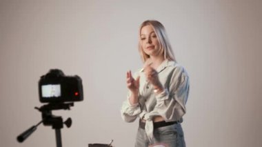 Makyaj hakkında video kaydeden genç bir kız fotoğraf makinesiyle tripoda bağlanmış.