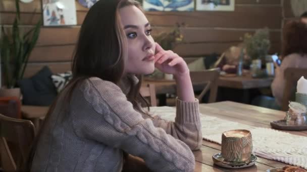 Bonito jovem asiático bonito menina sentado no mesa entediado, tendo café no aconchegante café — Vídeo de Stock