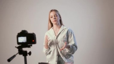 Genç kız video blogu kaydediyor ya da tripoda fotoğraf makinesi takılı özel ders veriyor
