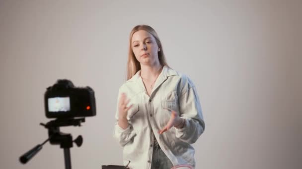 Young girl recording video blog or tutorial with photo camera attached to tripod — Stock Video