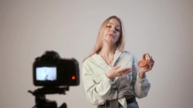 Makyaj hakkında video kaydeden genç bir kız fotoğraf makinesiyle tripoda bağlanmış.