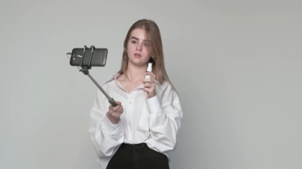 Giovane ragazza registrazione video su trucco con smartphone collegato al bastone selfie — Video Stock