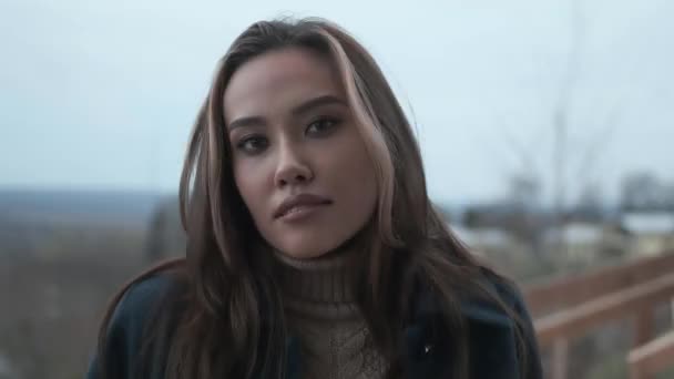 gros plan de élégant heureux asiatique jolie fille en manteau bleu et col roulé à l'extérieur 