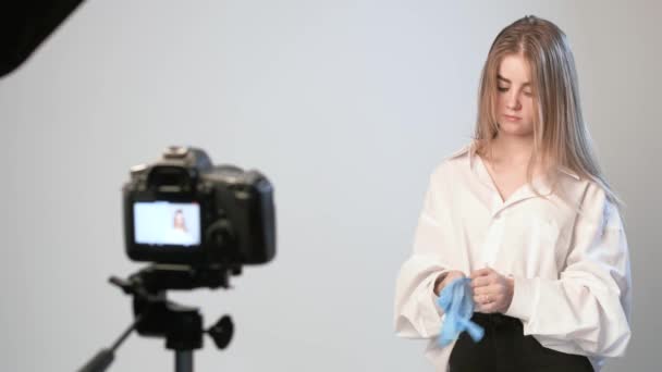 Beleza blogueiro apresenta cosméticos, de pé na frente da câmera de gravação de vídeo — Vídeo de Stock