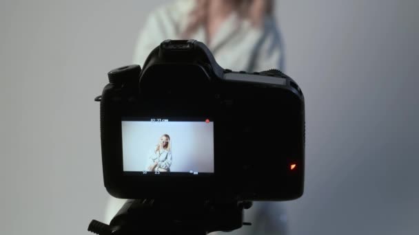Žena blogger mluví, nahrává video - zaměření na fotoaparát připojený k stativu — Stock video
