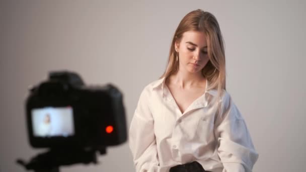 Beleza blogueiro apresenta cosméticos, de pé na frente da câmera de gravação de vídeo — Vídeo de Stock