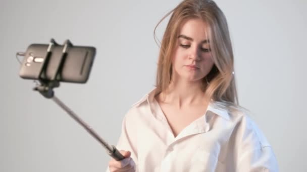 Jeune fille enregistrement vidéo sur le maquillage avec smartphone attaché à selfie stick — Video