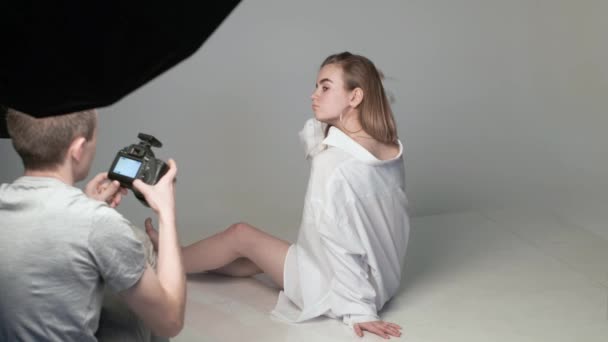 Színfalak mögött, férfi fotós, fotózás tini fehér lány pózol — Stock videók