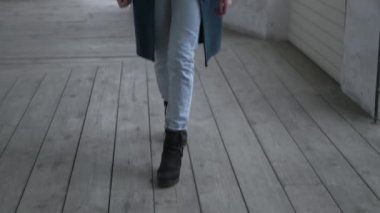 unrecognizable female in black boots stepping forward. Close up on thin legs