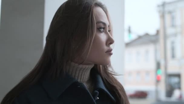 Asian thoughtful girl in blue coat posing on veranda with white stone columns — Stockvideo