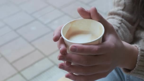 Mãos femininas segurando xícara de papel com café. menina segura caneca, close-up, sem rosto — Vídeo de Stock