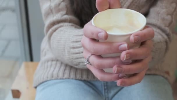 Manos femeninas sosteniendo taza de papel con café. chica sostiene taza, primer plano, sin cara — Vídeos de Stock