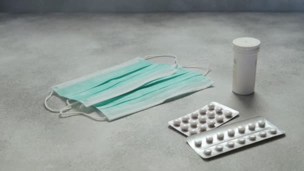 Lékařské masky, léky pilulky, kapsle, injekční lahvička na betonovém pozadí. zdravotní — Stock video