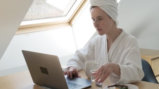 Внештатная женщина в белом халате, полотенце на голове. остаться дома карантин концепции — стоковое видео