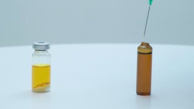 Bilim adamı doktorlar mavi eldivenleri teslim etti. İğne için aşı hazırlıyorlar.