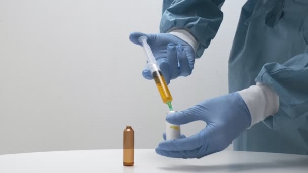 Orvos készíti elő az injekciót a betegnek a vakcinásüvegből. klinikai védőoltás — Stock videók