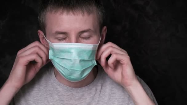 El joven se quita la máscara protectora. protección contra el virus, prevención de infecciones — Vídeo de stock