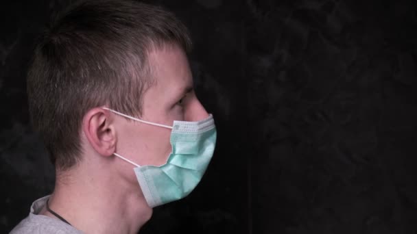 Jeune homme enlève le masque de protection. protection du virus, prévention de l'infection — Video