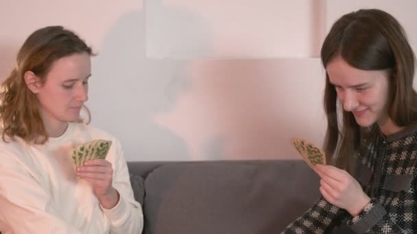 Freunde reden, pokern zu Hause, haben Spaß, lachen. Mädchen spielen Karten auf Couch — Stockvideo