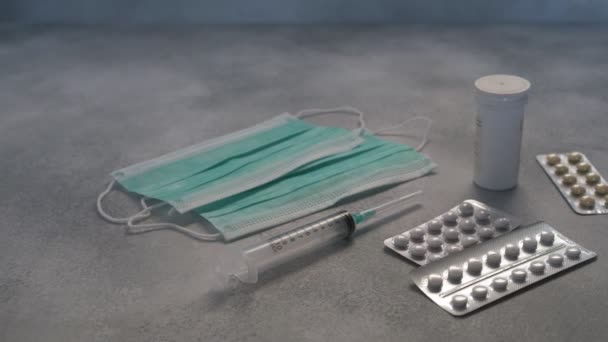 Masques médicaux, seringues, pilules médicinales, gélules, flacon sur fond de béton — Video