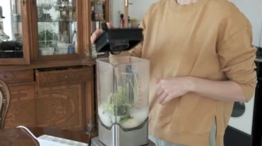 Mutfakta blender 'da meyve püresi hazırlayan genç bir kız. sağlıklı meyve diyeti