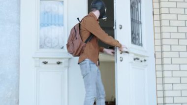 Kapı açılır, gaz maskeli genç adam evden çıkar, etrafa bakar ve gider.