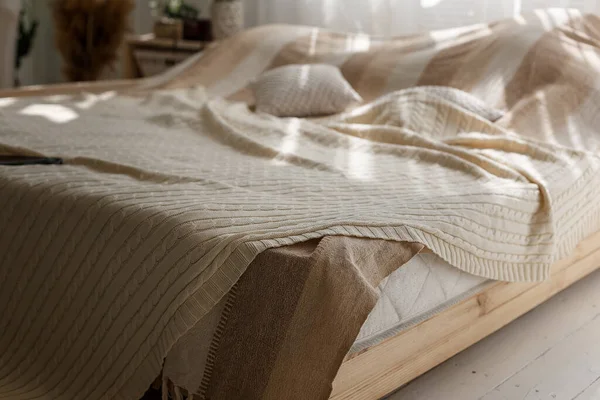 Nahaufnahme von Komfort-Doppelbett mit beigen Kissen und Decke, Sonnenstrahlen und Schatten im gemütlichen Schlafzimmer. — Stockfoto