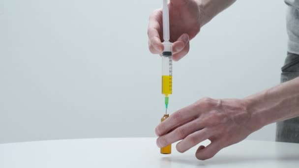 Man mains remplissage flacon avec de la solution de seringue. médecin préparant le vaccin — Video