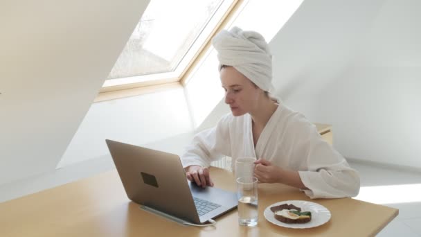 Stay home quarantine concept: freelance woman in white bathrobe, towel on head — Stock Video