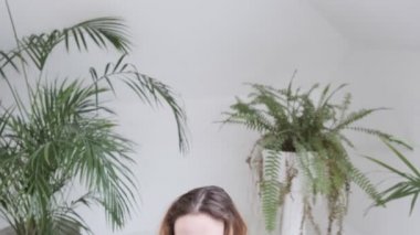 Spor kıyafetleri giyen hoş bir kız lotus pozisyonunda oturur, meditasyon yaparken güler.