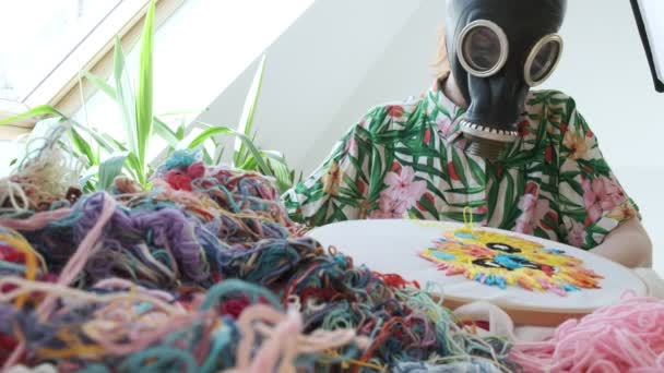 Stay home, quarantine leisure funny concept: needlework, handicraft in gas mask — Stock Video