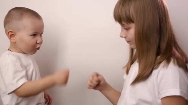 Glada barn spela spel rock papper sax på vit bakgrund, le och skratta — Stockvideo