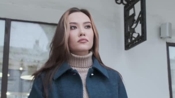 Крупный план стильной счастливой азиатской красивой девушки в голубом пальто и водолазке на открытом воздухе — стоковое видео