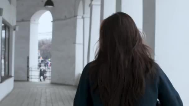 Közelről lányok vissza, személy elsétál, elegáns lány kabátban hosszú haj — Stock videók