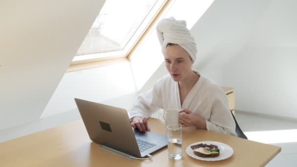 Пребывание дома карантин концепция: фрилансер в белом халате, полотенце на голове — стоковое видео