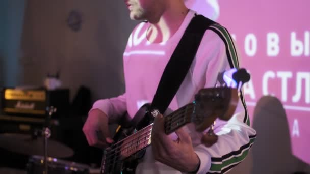 RUSSLAND, VLADIMIR, 27. Dezember 2019: gut aussehender Mann mit Brille spielt Bassgitarre — Stockvideo