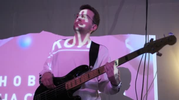 РОССИЯ, ВЛАДИМИР, 27 ДЕК 2019: хороший мужчина в очках играет на бас-гитаре — стоковое видео