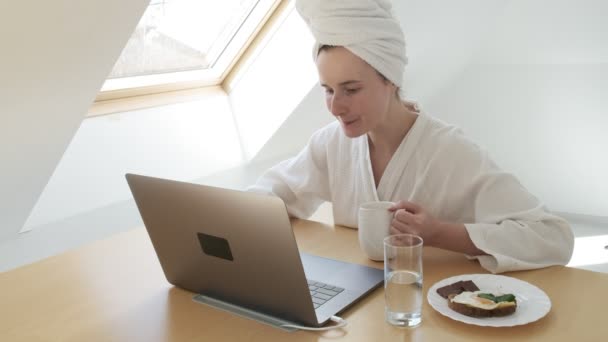 Stay home quarantine concept: freelance woman in white bathrobe, towel on head — Stock Video