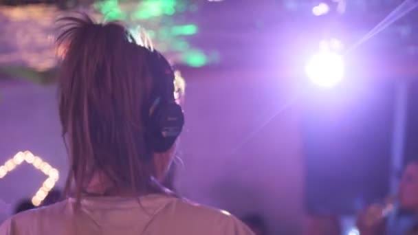 RUSIA, VLADIMIR, 27 DIC 2019: parte posterior de la chica rubia dj con auriculares bailando — Vídeo de stock