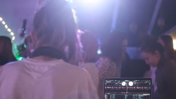 RUSIA, VLADIMIR, 27 DIC 2019: parte posterior de la chica rubia dj con auriculares bailando — Vídeo de stock